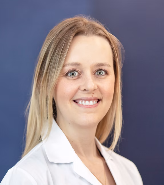 Ashley Sommerhalder, M.D. smiling in a white coat